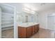 This bathroom is equipped with a double vanity, closet and separate shower at 40232 W Marion May Ln, Maricopa, AZ 85138