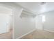 Light and bright bedroom with beige carpet featuring two doors and a closet at 40232 W Marion May Ln, Maricopa, AZ 85138