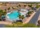 Large resort-style community pool with inviting lounge areas, surrounded by lush landscaping at 40232 W Marion May Ln, Maricopa, AZ 85138