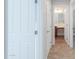 Bright hallway with multiple doors, a carpet and showing a bathroom with tile flooring at 40232 W Marion May Ln, Maricopa, AZ 85138