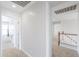 Upstairs hallway with carpet, multiple rooms, and access to staircase at 40232 W Marion May Ln, Maricopa, AZ 85138
