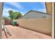 Side yard featuring a block wall, storage bins, and low-maintenance landscaping at 40232 W Marion May Ln, Maricopa, AZ 85138