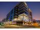 Modern condo building with glass balconies and manicured landscaping under a dramatic evening sky at 4422 N 75Th St # 8004, Scottsdale, AZ 85251