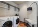 Well-lit laundry room with front-load washer and dryer, overhead shelving, and convenient bench at 4422 N 75Th St # 8004, Scottsdale, AZ 85251