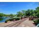 Picturesque train track bridge over a pond surrounded by lush greenery under a clear blue sky with mature green trees at 4516 W Fortune Dr, Phoenix, AZ 85086