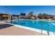 Community swimming pool featuring clear blue water, a diving board, and plenty of lounge chairs for a refreshing experience at 4516 W Fortune Dr, Phoenix, AZ 85086