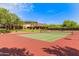 Exterior shot of a well-maintained tennis court, with manicured landscaping around the community building in the distance at 4516 W Fortune Dr, Phoenix, AZ 85086