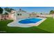 Backyard swimming pool featuring artificial turf and white concrete patio at 4549 W Poinsettia Dr, Glendale, AZ 85304