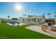 Backyard pool area featuring artificial turf and outdoor seating at 4549 W Poinsettia Dr, Glendale, AZ 85304