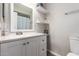 Bright bathroom with a white vanity, quartz countertop, framed mirror, and decorative floating shelves at 4549 W Poinsettia Dr, Glendale, AZ 85304