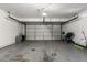 Spacious two car garage featuring white brick walls and an automatic garage door at 4549 W Poinsettia Dr, Glendale, AZ 85304