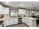 Open kitchen with white cabinetry, stainless steel appliances, breakfast bar, and modern pendant lighting at 4549 W Poinsettia Dr, Glendale, AZ 85304