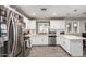 Well-lit kitchen featuring white cabinets, stainless steel appliances, tile backsplash, and wood-look floors at 4549 W Poinsettia Dr, Glendale, AZ 85304