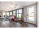 Sunroom living room featuring a tile floor, ceiling fans, and large windows overlooking backyard at 4549 W Poinsettia Dr, Glendale, AZ 85304