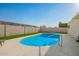 Backyard swimming pool and patio featuring artificial turf and perimeter block fence at 4549 W Poinsettia Dr, Glendale, AZ 85304