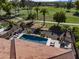 Aerial view of a home with pool, hot tub, outdoor kitchen, lounge chairs, and nearby golf course at 4822 N Barranco Dr, Litchfield Park, AZ 85340