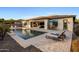 Beautiful backyard featuring a pool, covered patio, and lush landscaping, perfect for outdoor relaxation and entertainment at 4822 N Barranco Dr, Litchfield Park, AZ 85340