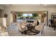 Covered patio with comfortable seating, overlooking the sparkling pool and lush green landscape at 4822 N Barranco Dr, Litchfield Park, AZ 85340
