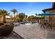 Lush backyard oasis featuring a pool with waterfall, dining area, lounge chairs, and mature landscaping at 4822 N Barranco Dr, Litchfield Park, AZ 85340