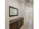 Hallway featuring dark wood storage cabinets, a full length mirror, and tile flooring, combining style and function at 4822 N Barranco Dr, Litchfield Park, AZ 85340