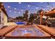 Backyard featuring a hot tub, pool, outdoor kitchen, chaise lounges, and shaded pergola for relaxing evenings at 4822 N Barranco Dr, Litchfield Park, AZ 85340