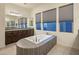 Elegant bathroom with a large soaking tub, custom cabinets, and ample natural light for a peaceful atmosphere at 4822 N Barranco Dr, Litchfield Park, AZ 85340
