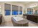 Luxurious bathroom with soaking tub, vanity, and windows that create a spa-like experience at 4822 N Barranco Dr, Litchfield Park, AZ 85340