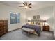 Comfortable main bedroom with a decorative bed, soft carpet, and bright natural light from a large window at 4822 N Barranco Dr, Litchfield Park, AZ 85340