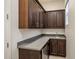 Pantry featuring rich wood cabinets, sleek gray countertops, and stainless steel appliances, perfect for organization at 4822 N Barranco Dr, Litchfield Park, AZ 85340
