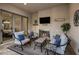 Relaxing covered patio featuring a cozy fireplace, comfortable seating, and seamless indoor-outdoor flow at 4822 N Barranco Dr, Litchfield Park, AZ 85340