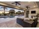Relaxing covered patio with fireplace overlooks pool, golf course, and lush landscaping, offering serene outdoor living at 4822 N Barranco Dr, Litchfield Park, AZ 85340