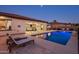 Relaxing poolside view with outdoor lounge area, manicured landscaping, and covered patio with ceiling fans at 4822 N Barranco Dr, Litchfield Park, AZ 85340