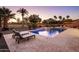 Sparkling pool with waterfall feature, surrounded by lounge chairs and lush landscaping against a scenic backdrop at 4822 N Barranco Dr, Litchfield Park, AZ 85340