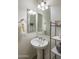 Stylish powder room featuring a pedestal sink, decorative mirrors, and modern fixtures for guests' convenience at 4822 N Barranco Dr, Litchfield Park, AZ 85340