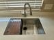 Stainless steel kitchen sink featuring modern faucet and a cutting board cover at 6120 N 30Th Ave, Phoenix, AZ 85017