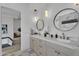 Stylish bathroom featuring double sinks, round mirrors, modern lighting fixtures and marble countertops at 6184 E Dusty Coyote Cir, Scottsdale, AZ 85266