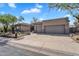 Attractive home featuring desert landscaping, a spacious driveway, and a three-car garage at 6184 E Dusty Coyote Cir, Scottsdale, AZ 85266