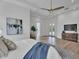 Bright main bedroom featuring a ceiling fan, exterior door, and modern decor and light wood floors at 6184 E Dusty Coyote Cir, Scottsdale, AZ 85266
