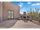 Outdoor fireplace with flagstone patio and landscaped yard at 6184 E Dusty Coyote Cir, Scottsdale, AZ 85266