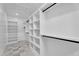Spacious walk-in closet with custom shelving and marble flooring at 6184 E Dusty Coyote Cir, Scottsdale, AZ 85266