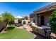 Outdoor patio featuring a grill, seating, green turf, a manicured garden, table and chairs with umbrella, and brick at 6202 E Mckellips Rd # 183, Mesa, AZ 85215