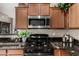 Updated kitchen showcasing black countertops, stainless steel microwave, and gas range at 6202 E Mckellips Rd # 183, Mesa, AZ 85215
