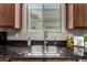 Well-lit kitchen featuring a stainless steel sink, black granite counters and tiled flooring at 6202 E Mckellips Rd # 183, Mesa, AZ 85215