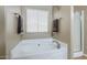 Corner bathtub with tile flooring, neutral walls, and natural light at 637 E Settlers Trl, Casa Grande, AZ 85122