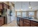 Modern kitchen with stainless steel refrigerator and island featuring dark wood cabinets at 637 E Settlers Trl, Casa Grande, AZ 85122