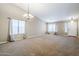 Spacious living room featuring high ceilings, carpet floors, and natural light from large windows at 637 E Settlers Trl, Casa Grande, AZ 85122