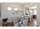 Bright dining room with glass table, upholstered chairs and modern chandelier open to the kitchen at 6939 E Bramble Berry Ln, Scottsdale, AZ 85266
