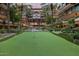Community putting green surrounded by lush landscaping, water feature, and modern condominiums at 7141 E Rancho Vista Dr # 6007, Scottsdale, AZ 85251