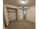 Bedroom with neutral carpet, closet, white trim, and easy access to the hallway at 7905 W Thunderbird Rd # 305, Peoria, AZ 85381
