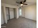Bedroom featuring neutral carpet, ceiling fan, and a closet with easy access to the hallway at 7905 W Thunderbird Rd # 305, Peoria, AZ 85381
